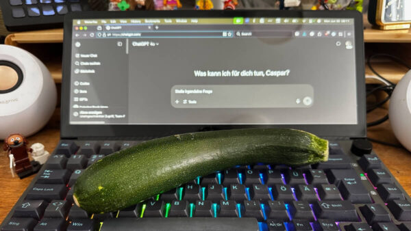 Eine Zucchini auf einer mechanischen Tastatur mit einem Bildschirm mit ChatGPT Prompt